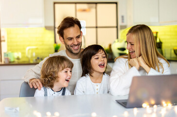 Fototapeta premium Happy young family using laptop at home 