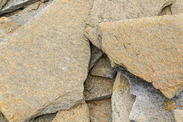 Stone natural flagstone piled in a pile. Natural stone flagstone, laid in uneven rows. Background .