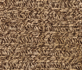 Texture of a surface of a rough brown wool knitted fabric