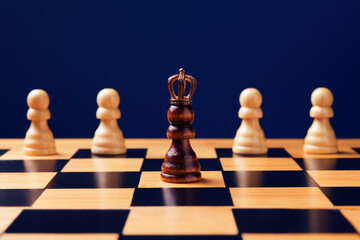 Black pawn in crown among whites on chess board. Personal Growth and Development concept. Selective focus