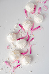 meringue on a white table with pink petals