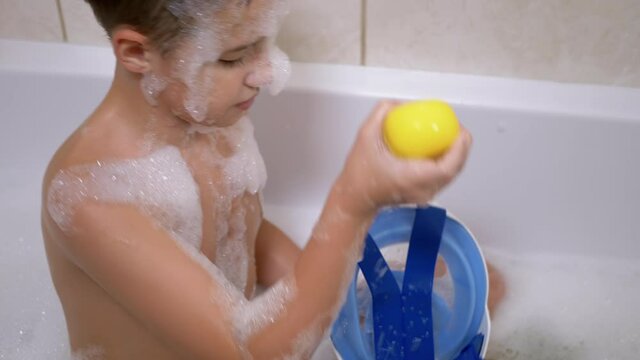Charming Boy Bathes in Bath with Foam, Playing with Blue Mask for Diving