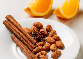 almonds, cinnamon sticks and orange wedges