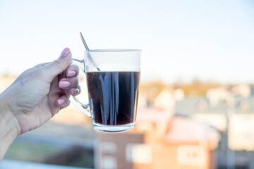 Morning coffee. Woman holds a hot coffee .coffee break and relax concept ,view to transparent coffee cup of city background.