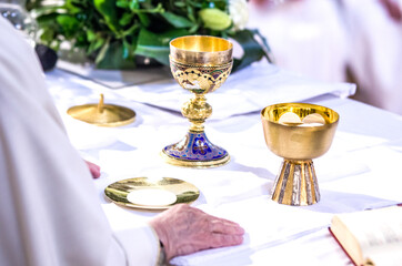 hands of Pope Francis with host and chalice with wine in the churches of the world