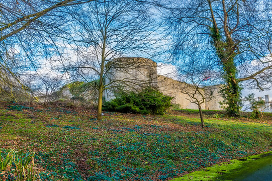 A view of Barnwell Castle hidden in trees near Oundle, UK on a bright sunny day