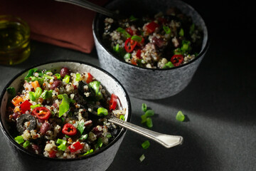 Two bowls with quinoa, paprika, beans and olives