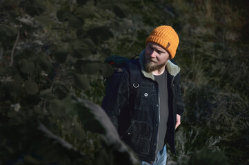 Portrait of a young lamber hiking man in forrest in automn and looking away. Concept of people traveling in nature.