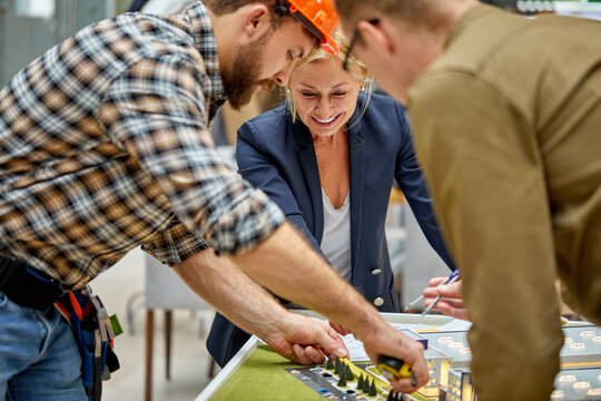 team of architects plan complex building model, 3d model construction, discussing brainstorming in the office - Powered by Adobe
