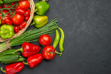 Half shot of fresh various organic vegetables in wicker basket on dark background