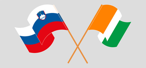 Crossed and waving flags of Slovenia and Republic of Ivory Coast