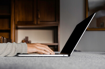 Smart working. Side view and close up of woman's hands typing on laptop keyboard
