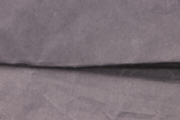 Black, crumpled aged paper in the middle. Empty background and texture.