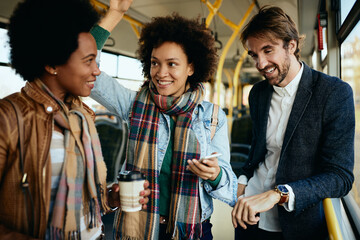 Group of happy friends talking while traveling by bus.