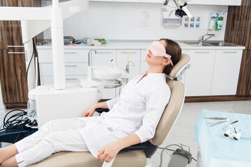 A dentist relaxing in her office after a long work day.