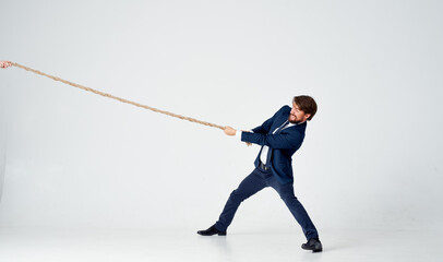 Fototapeta premium man with rope in hand on light background business finance 