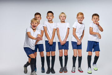 team of soccer players ready to take the ball, stood in a row, closing lower part of body, isolated portrait