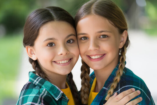 Happy girls smile with cute look wearing long hair in plaits summer outdoors, beauty
