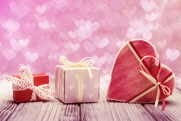 Three gift boxes over heart shaped defocused lights. Valentines day concept