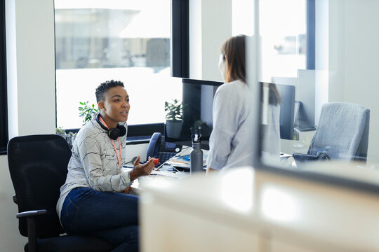 Businesswomen talking at computer in office