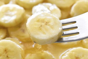 Banana with honey on a white plate.