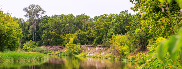 A view of the river with wooded banks, panorama, banner, summer natural landscape