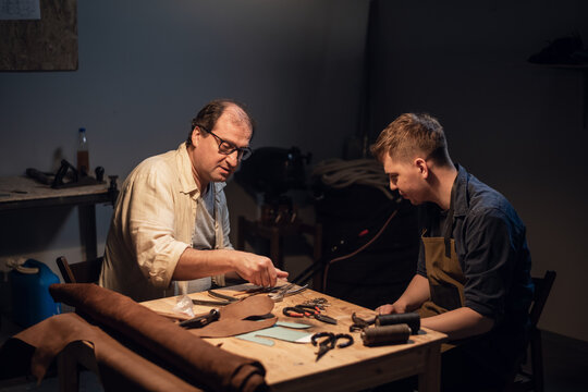 an elderly shoemaker and his apprentice create shoes by hand in their workshop with various tools