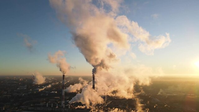 Smoking factory chimneys. Environmental problem of pollution of environment and air in large cities. View of large plant with Smoking pipes. Industry pipes pollute the atmosphere with smoke