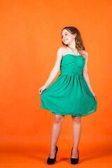 Gorgeous and beautiful. happy childhood. small girl has long lush hair. kid in dress. female hairdresser salon. beauty and summer fashion. cheerful child on orange background. trendy kid in dress