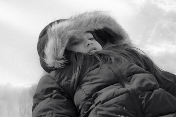 portrait of a girl laying on white snow, black and white
