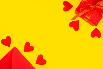 Valentine's Day background. Gift, envelope, hearts on a yellow background. Valentine's Day concept. Flat lay, top view, copy space