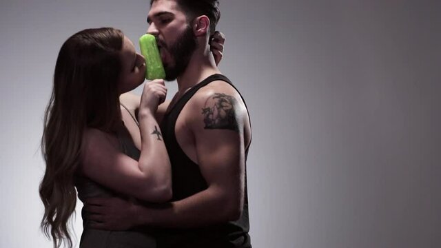 Man and woman sensually sharing flavored ice