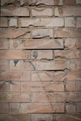 Brick wall with red cracked and damaged stones, background with space for text, vertical format 