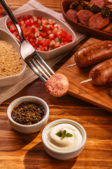 Fork serving grilled pork sausage with chimichurri - Close up