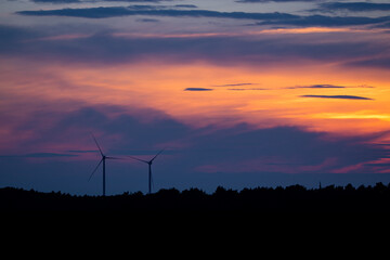 zwei Windräder im Sonnenuntergang