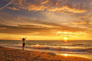 Fototapeta na wymiar Happy woman on the sunset beach