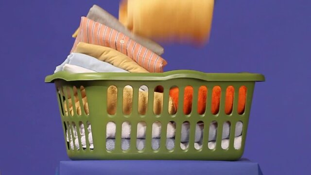 Folded towels falling into laundry basket