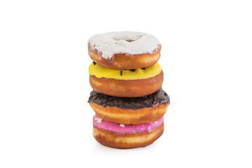 a stack of traditional American donuts with chocolate, yellow, white, pink icing and sprinkles on a white plate.