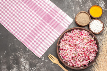 Horizontal view of delicious vegetable salad pink stripped towel different spices and fork on dark table