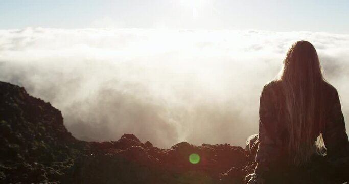 Caucasian woman on top of the Haleakala Crater watching sunrise