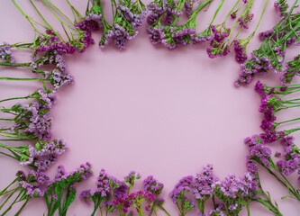 Frame of pink and purple flowers on a pink background