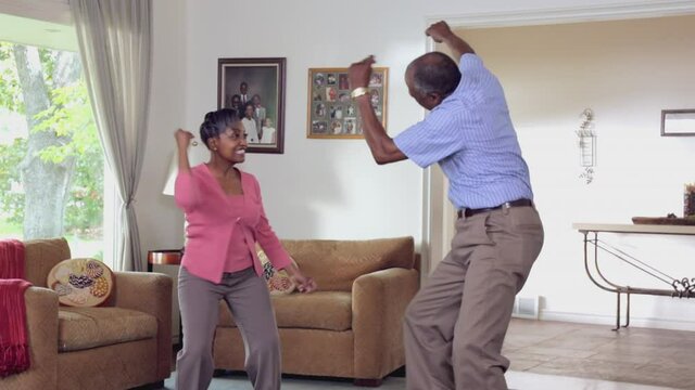 Happy Middle-aged Black Couple Dancing In Livingroom