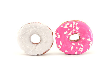 two traditional American donuts with pink and white icing and sprinkles isolated on a white