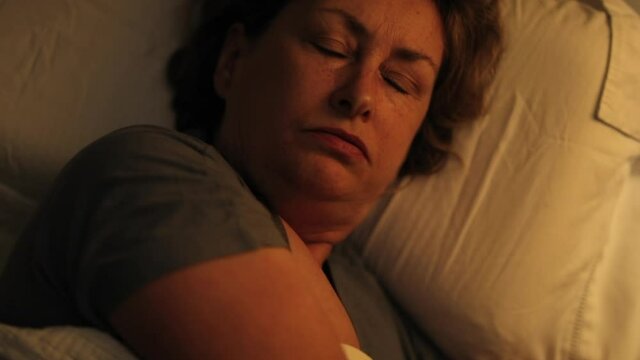 Tired sleepless older woman lying in bed unable to sleep
