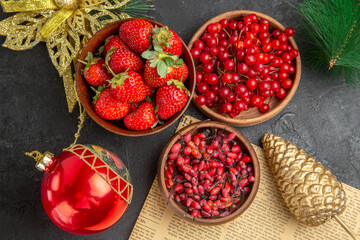top view fresh red cranberries with other fruits around christmas toys on a dark background fruit color xmas holiday berry