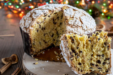 Delicious Christmas panettone with chocolate and dry fruits on the wooden table, festive decorated.Traditional spanish panettone navidad.