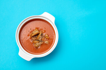 tomato soup in white bowl on red background