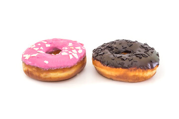 two traditional American donuts with chocolate and pink icing and sprinkles on a white plate.