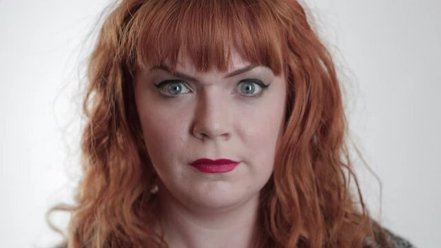 Close up of Caucasian woman with red hair raising eyebrows