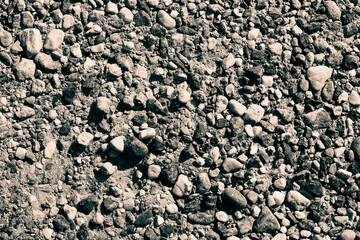 background formed of stones of different shapes and colors scattered on the ground